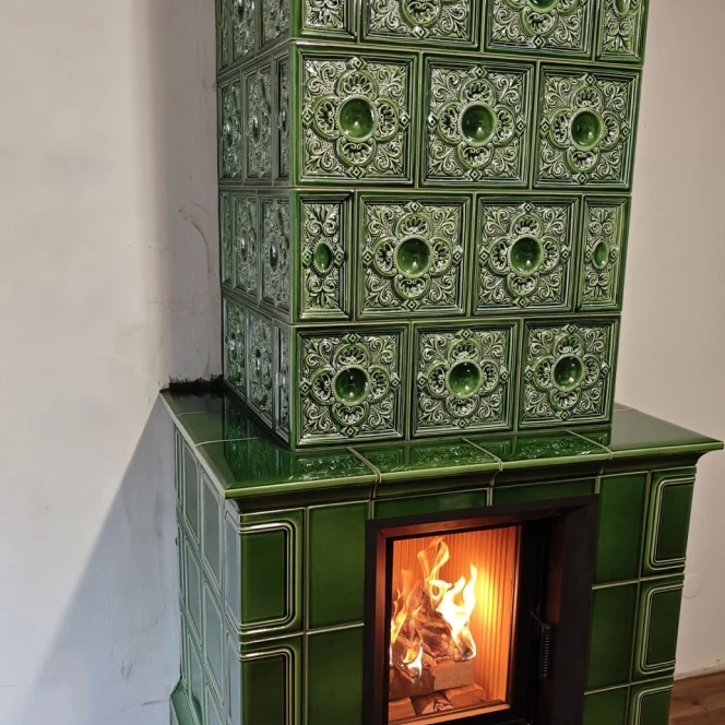 Piec kaflowy w głębokiej zieleni ze zdobieniami