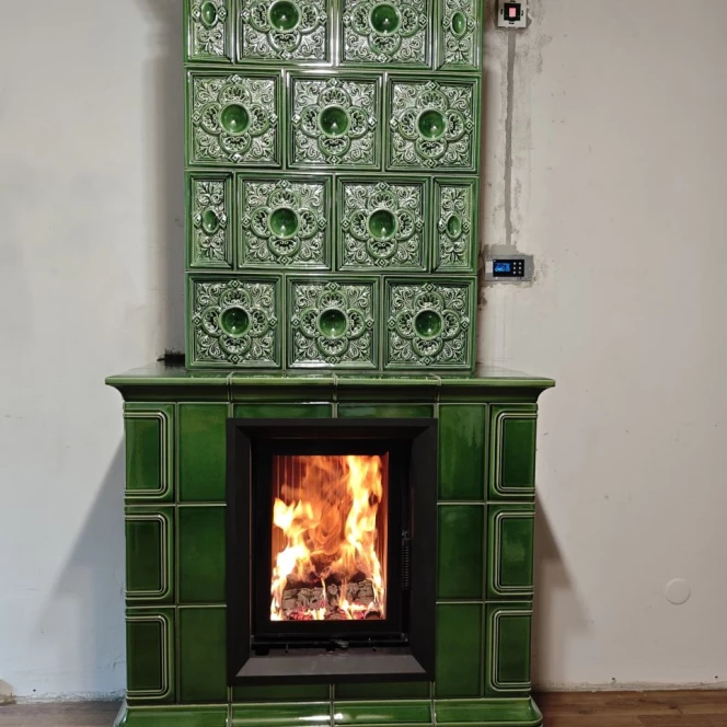 Piec kaflowy w głębokiej zieleni ze zdobieniami