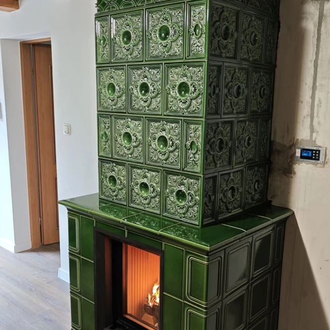 Piec kaflowy w głębokiej zieleni ze zdobieniami