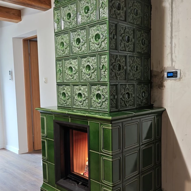 Piec kaflowy w głębokiej zieleni ze zdobieniami