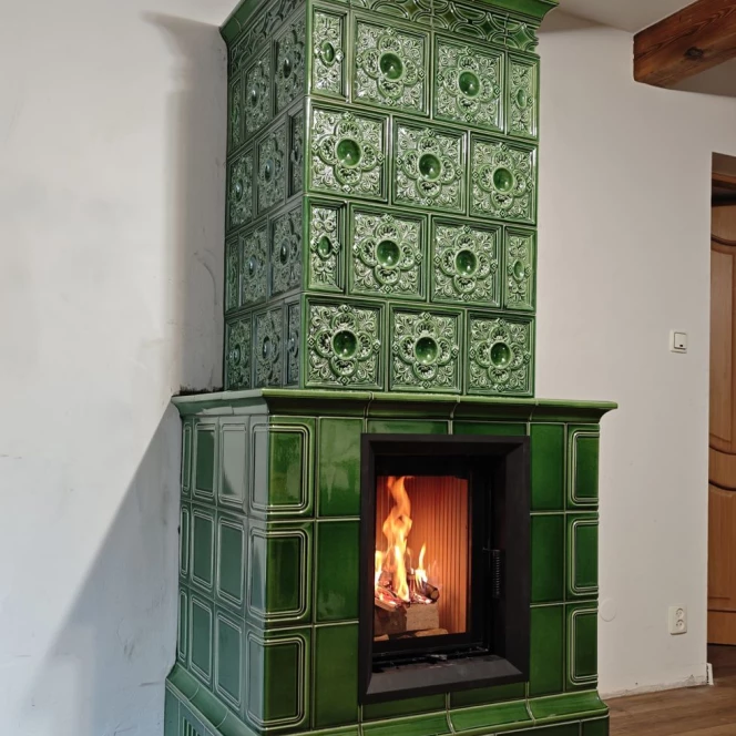 Piec kaflowy w głębokiej zieleni ze zdobieniami